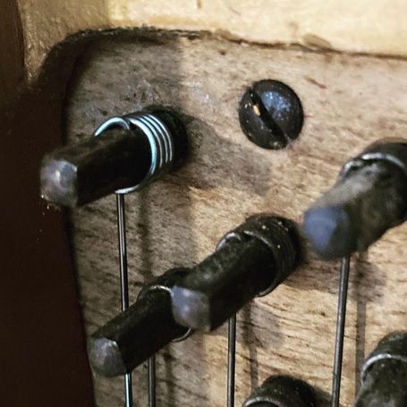 Vue du sommier et de la cheville d'une corde de piano acier neuve